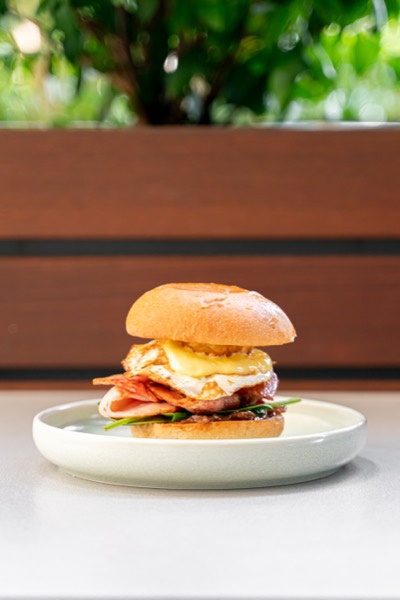A breakfast burger with egg and bacon on a brioche bun